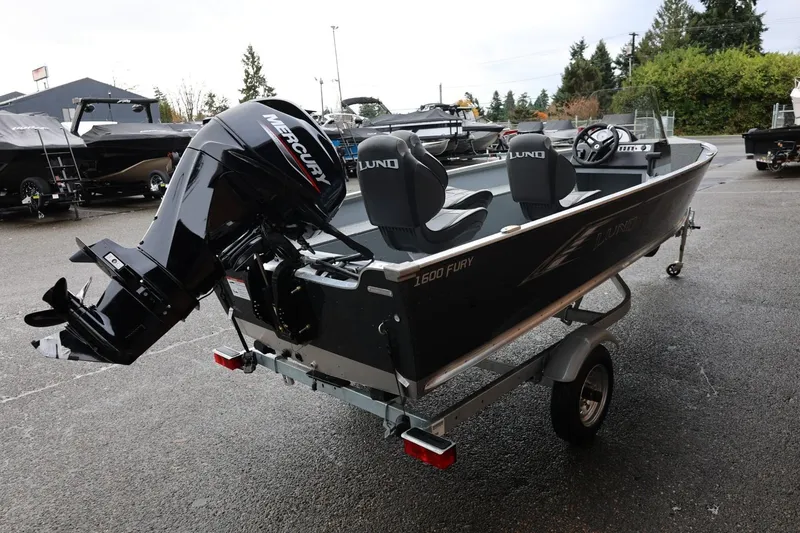 Slide: The Image of 2026 Lund 1600 Fury SS boat with Mercury engine on trailer, parked outdoors. - 7