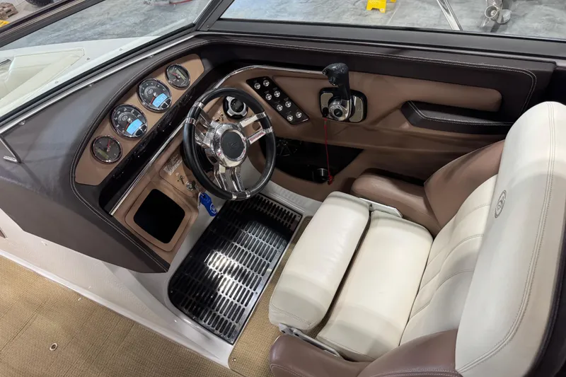 Slide: The Image of 2012 Cobalt 276 boat interior with steering wheel, gauges, and white leather seating. - 16
