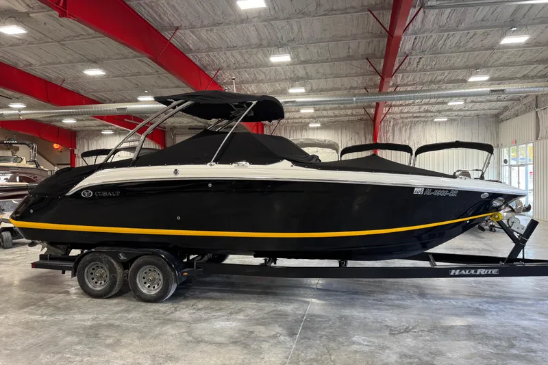 Slide: The Image of 2012 Cobalt 276 boat in showroom, black with yellow stripe, on trailer. - 18