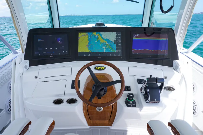 Slide: The Image of 2023 HCB 53 Sueños boat cruising on clear blue ocean waters under a partly cloudy sky. - 29