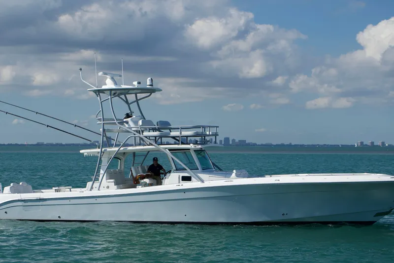 Slide: The Image of 2024 HCB 53 Sueños boat cruising on calm ocean waters under a partly cloudy sky. - 1