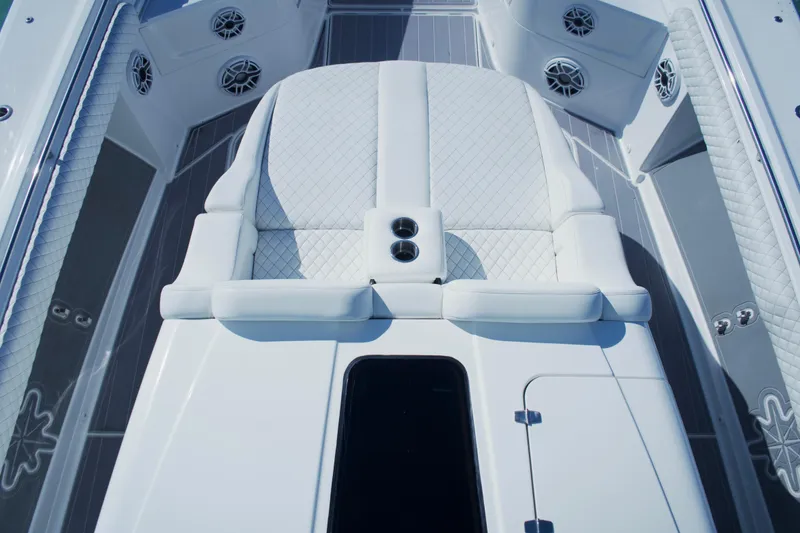 Slide: The Image of Luxurious 2023 HCB 53 Sueños boat interior with seating and cup holders on open water. - 16