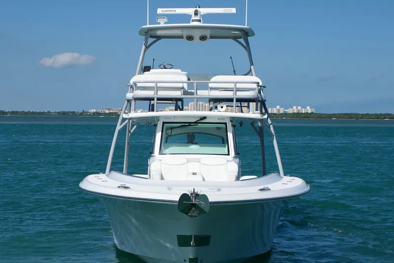 Slide: The Image of 2023 HCB 53 Sueños boat cruising on open water under blue sky. - 2