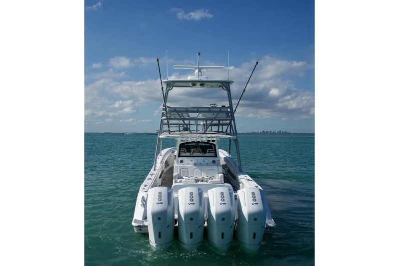 Slide: The Image of 2023 HCB 53 Sueños boat cruising on clear blue ocean under a partly cloudy sky. - 4