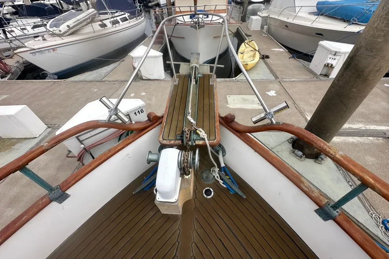 Slide: The Image of 1976 Grand Banks Sedan boat docked at marina, featuring wooden deck and railing. - 12