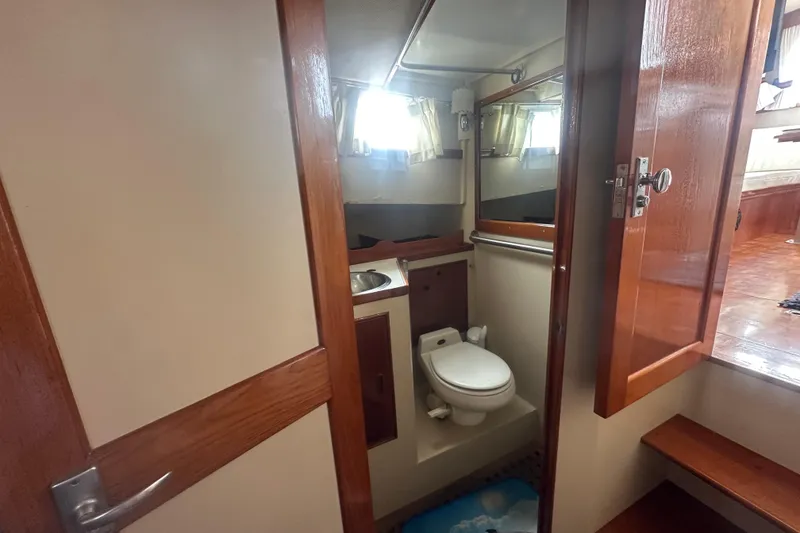 Slide: The Image of 1976 Grand Banks Sedan bathroom with wooden accents and compact design. - 14