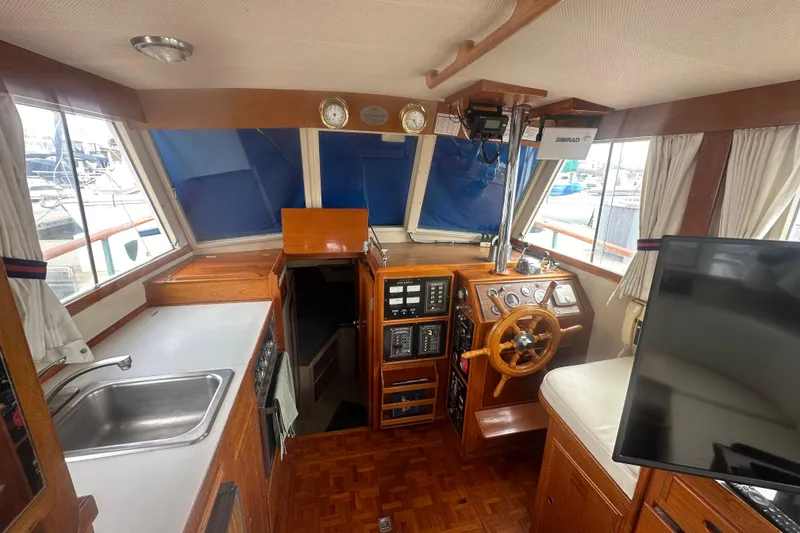Slide: The Image of 1976 Grand Banks Sedan interior with wooden helm, steering wheel, and nautical instruments. - 4