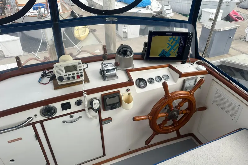 Slide: The Image of 1976 Grand Banks Sedan helm with wooden wheel, navigation instruments, and marine electronics. - 7