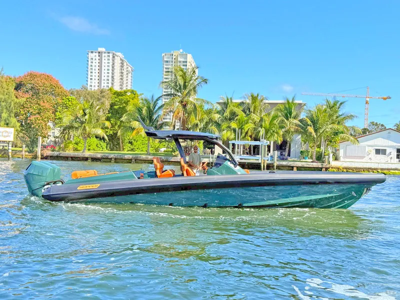 Slide: The Image of 2025 Skipper-BSK 38 boat cruising on a sunny day near palm trees and buildings. - 5