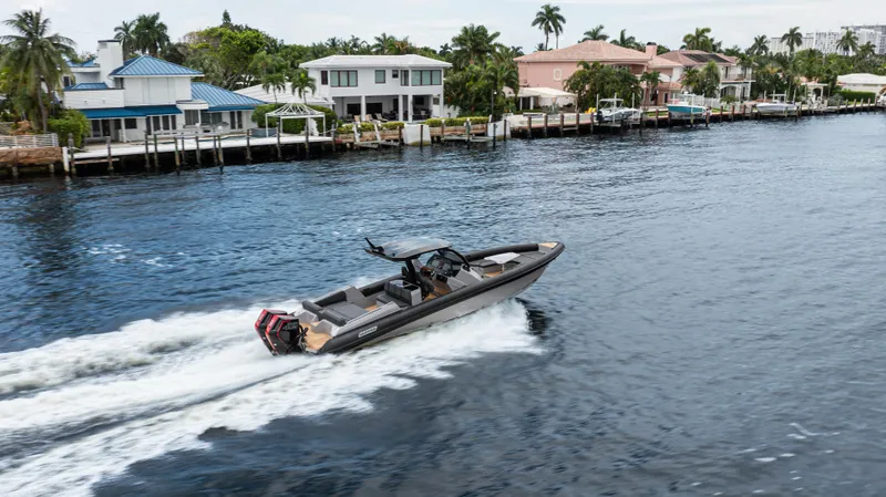 Slide: The Image of 2025 Skipper-BSK 38 boat cruising on a scenic waterfront with luxury homes. - 39