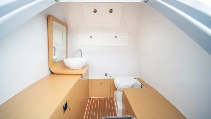 Slide: The Image of Modern boat bathroom with wooden accents, featuring a sink and toilet. Skipper-BSK 38, 2025 model. - 17