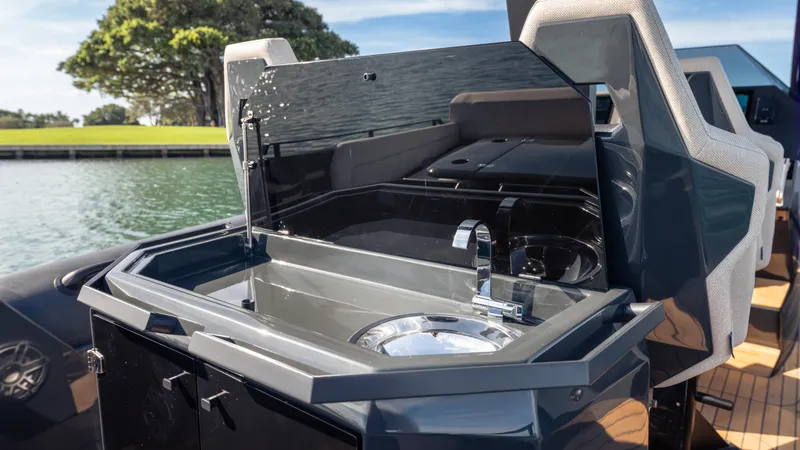 Slide: The Image of 2025 Skipper 38 boat with sleek outdoor sink and faucet, docked by a scenic waterfront. - 26