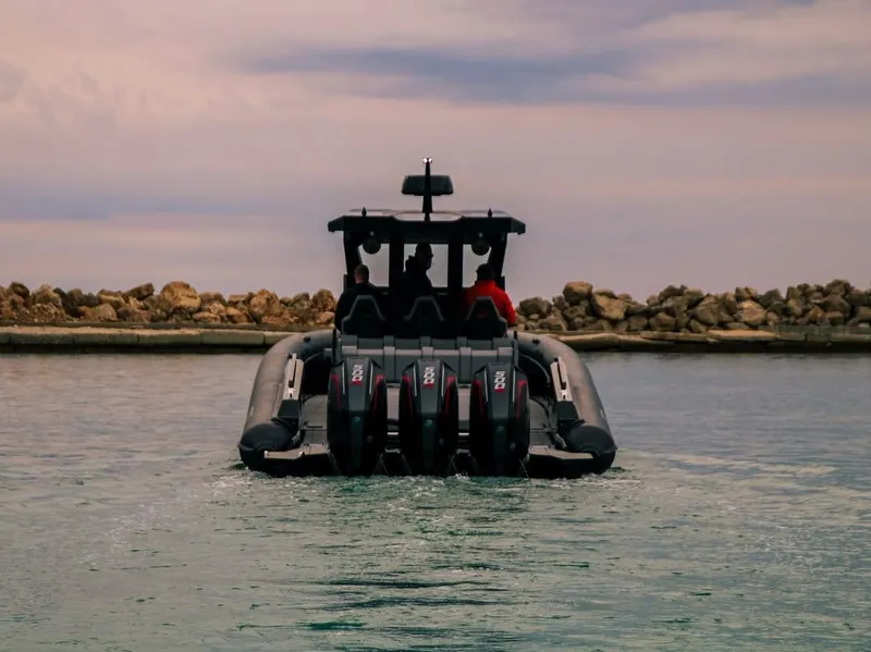 Slide: The Image of Skipper-BSK 42 boat, 2026 model, cruising on water with rocky shoreline background. - 2
