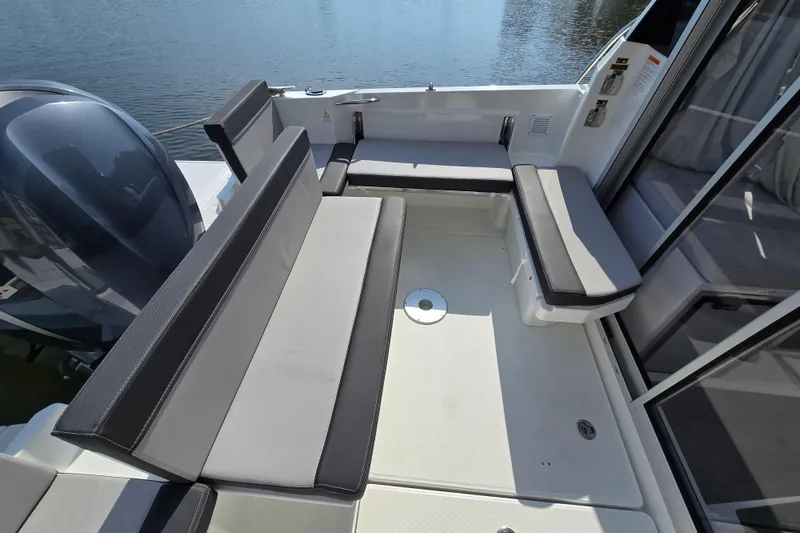 Slide: The Image of 2023 Jeanneau NC Sport 795 Series 2 boat interior with cushioned seating and motor view. - 11