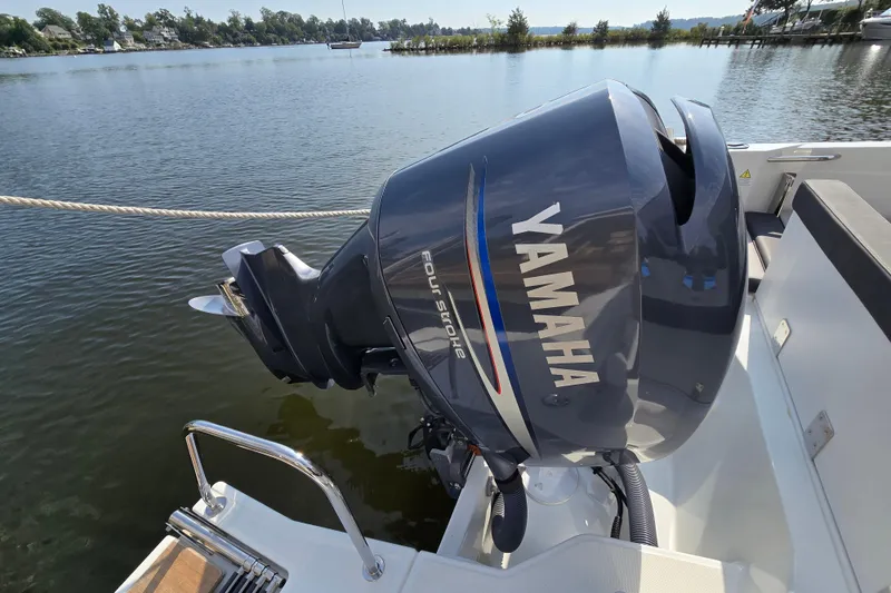 Slide: The Image of 2023 Jeanneau NC Sport 795 Series 2 with Yamaha outboard motor on a calm lake. - 18