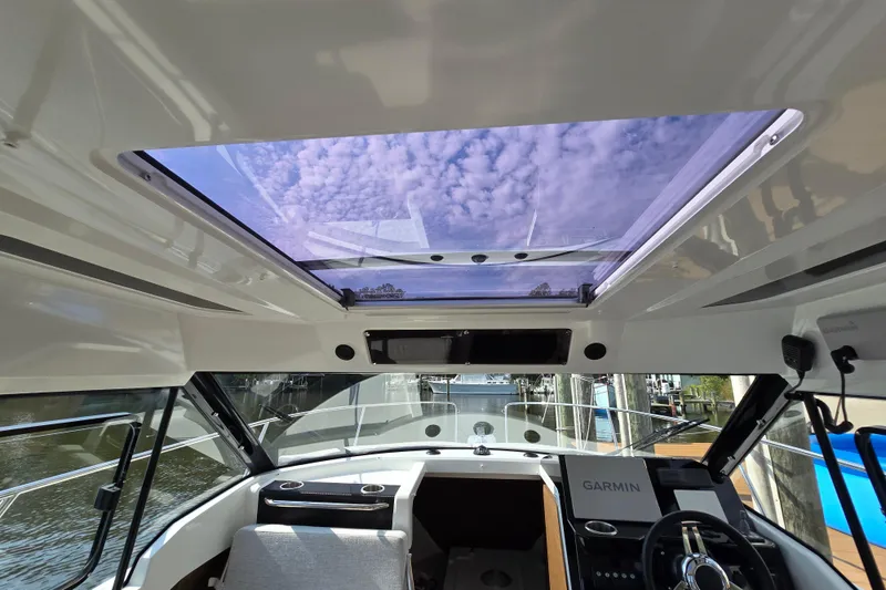Slide: The Image of Interior view of 2023 Jeanneau NC Sport 795 Series 2 boat with sunroof and Garmin navigation. - 24