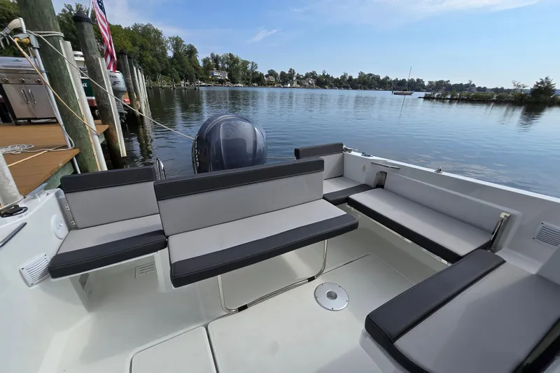 Slide: The Image of 2023 Jeanneau NC Sport 795 Series 2 boat interior with seating, docked by a serene lake. - 49