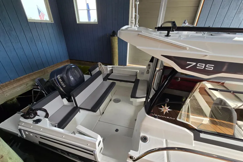 Slide: The Image of 2023 Jeanneau NC 795 Series 2 boat docked indoors, featuring Yamaha outboard motor. - 63