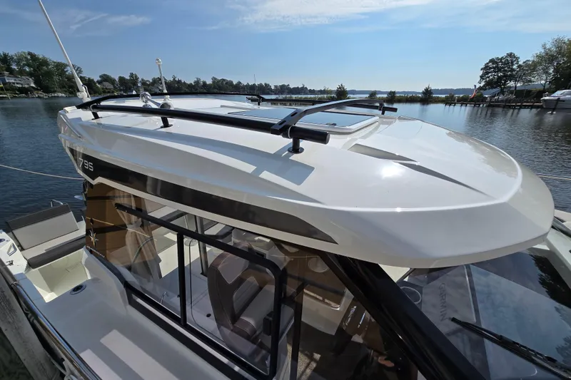 Slide: The Image of 2023 Jeanneau NC Sport 795 Series 2 boat docked by a serene lake. - 8