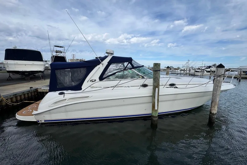 The Image of 2000 Sea Ray 410 Sundancer yacht docked at marina under cloudy sky. - 0
