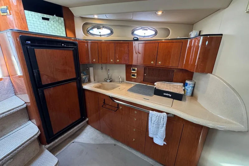 Slide: The Image of Luxurious 2000 Sea Ray 410 Sundancer yacht kitchen with wood cabinetry and modern amenities. - 14