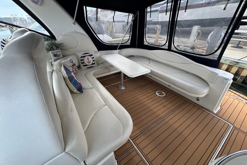 Slide: The Image of Luxurious interior of 2000 Sea Ray 410 Sundancer yacht with white seating and wooden flooring. - 4