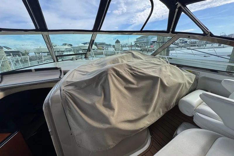 Slide: The Image of 2000 Sea Ray 410 Sundancer cockpit with covered seating, marina view in background. - 8