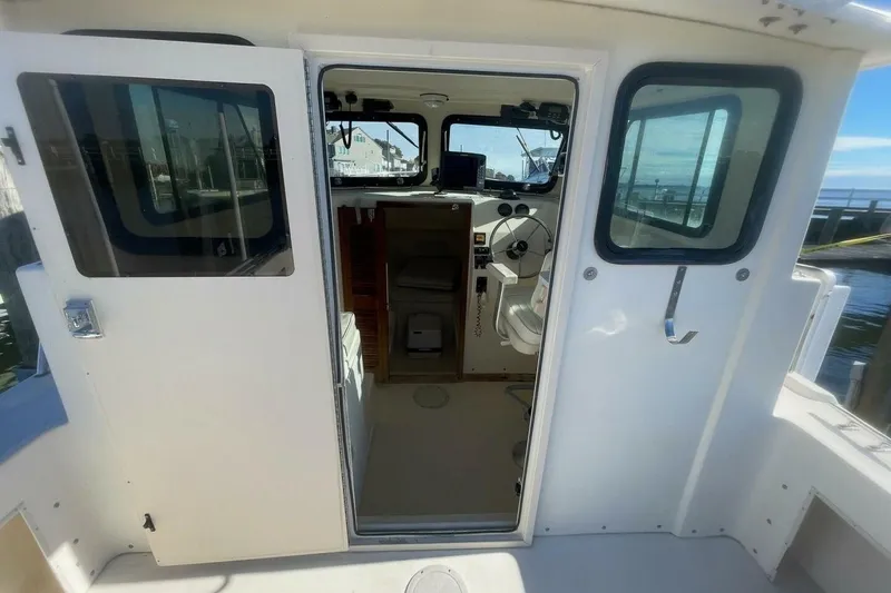 Slide: The Image of 2001 Parker 2520 Sport Cabin boat interior with steering wheel and controls. - 10