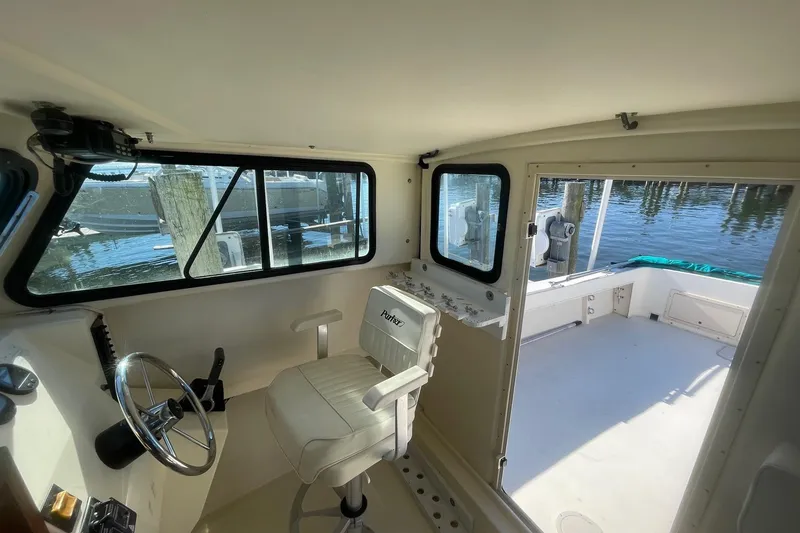 Slide: The Image of Interior view of 2001 Parker 2520 Deep Vee Sport Cabin boat, featuring helm and seating. - 3