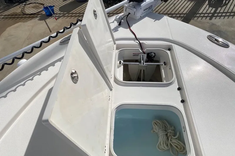 Slide: The Image of 2023 Robalo 246 Cayman SD boat deck with open storage compartments and rope. - 15