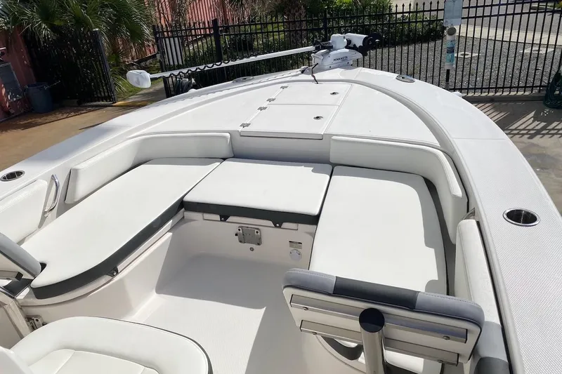 Slide: The Image of 2023 Robalo 246 Cayman SD boat interior with white seating and storage compartments. - 17