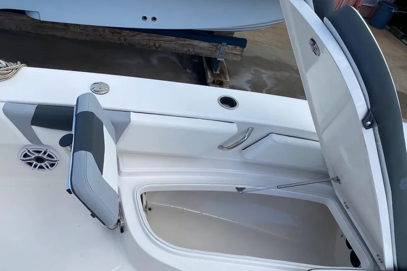 Slide: The Image of 2023 Robalo 246 Cayman SD boat storage compartment with open hatch and seating. - 19