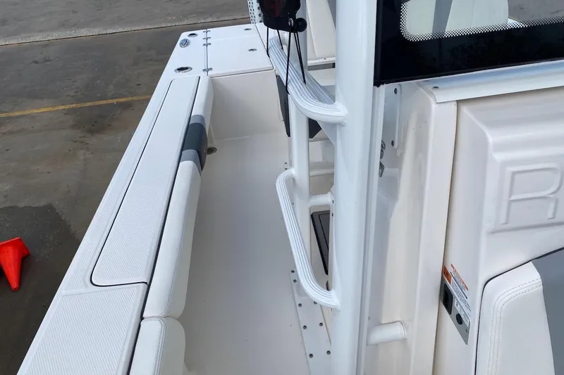 Slide: The Image of 2023 Robalo 246 Cayman SD boat interior with white seating and sleek design. - 25