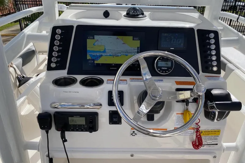 Slide: The Image of 2023 Robalo 246 Cayman SD boat dashboard with steering wheel and navigation system. - 28