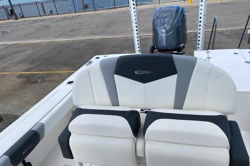 Slide: The Image of 2023 Robalo 246 Cayman SD boat interior with cushioned seating and outboard motor. - 30