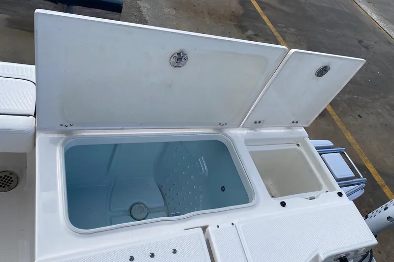 Slide: The Image of 2023 Robalo 246 Cayman SD boat storage compartments open on deck. - 35