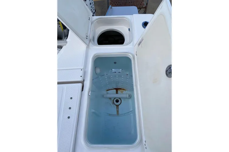 Slide: The Image of 2023 Robalo 246 Cayman SD boat storage compartments with open lids. - 36