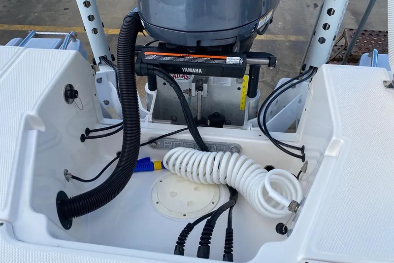 Slide: The Image of 2023 Robalo 246 Cayman SD boat engine compartment with Yamaha motor and coiled hose. - 38