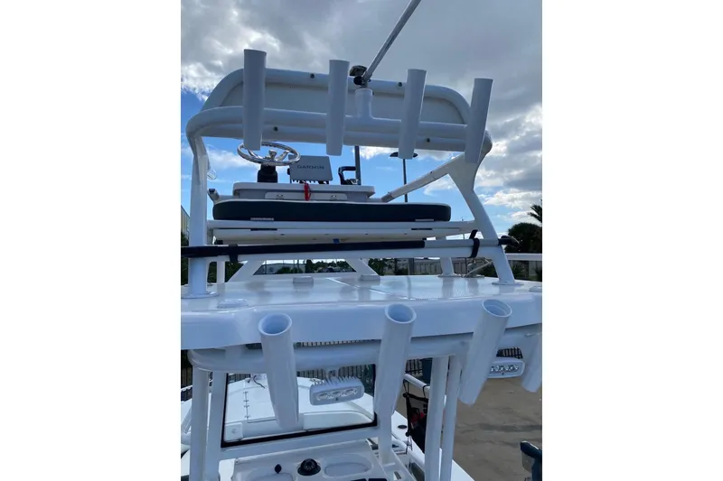 Slide: The Image of 2023 Robalo 246 Cayman SD boat with rod holders and Garmin equipment under cloudy sky. - 39