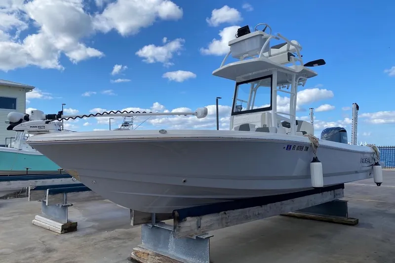 Slide: The Image of 2023 Robalo 246 Cayman SD boat on display under a clear blue sky. - 4