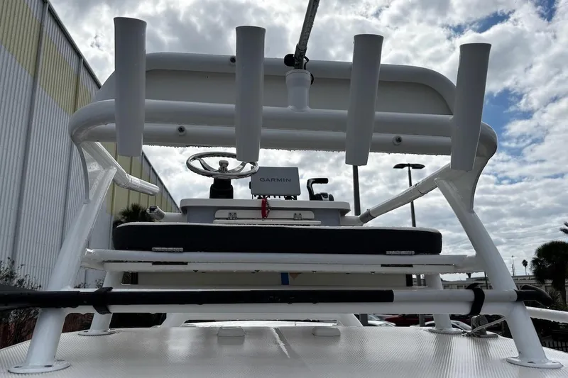 Slide: The Image of 2023 Robalo 246 Cayman SD boat with rod holders and Garmin equipment under cloudy sky. - 41
