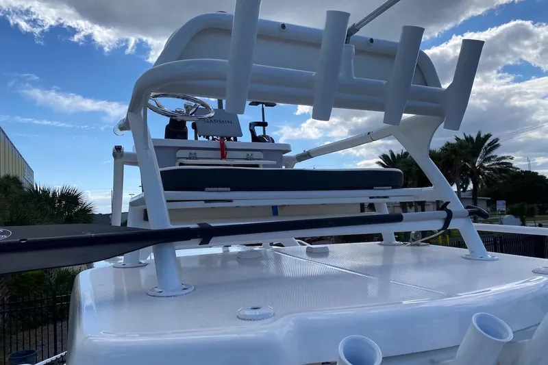 Slide: The Image of 2023 Robalo 246 Cayman SD boat with rod holders and steering wheel under a cloudy sky. - 42