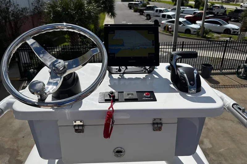 Slide: The Image of 2023 Robalo 246 Cayman SD helm with steering wheel, controls, and navigation display. - 44