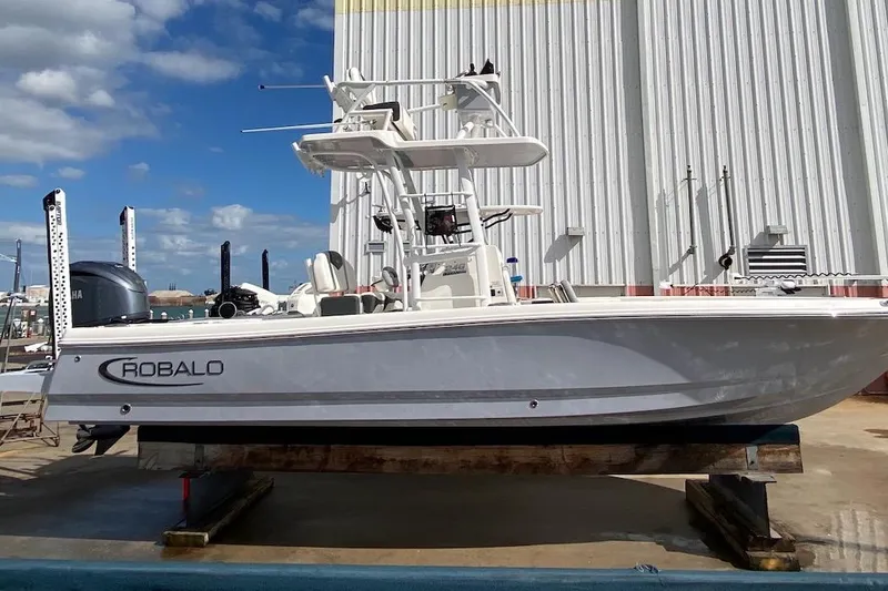 Slide: The Image of 2023 Robalo 246 Cayman SD boat on display, side view, outdoors. - 45