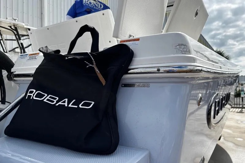 Slide: The Image of 2023 Robalo 246 Cayman SD boat with branded bag on deck. - 52