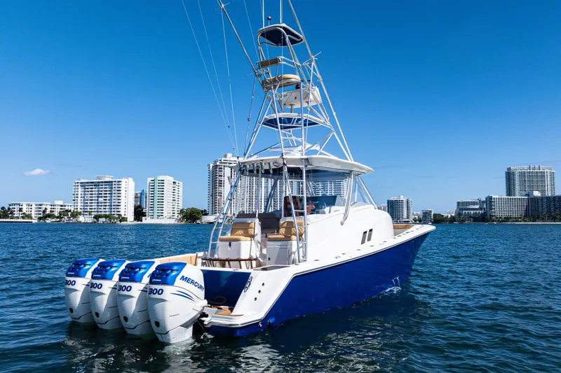 Slide: The Image of 2016 SeaVee 430 boat with four Mercury engines on a sunny day, city skyline in background. - 103