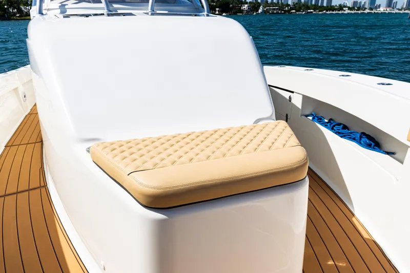 Slide: The Image of 2016 SeaVee 430 boat with cushioned seating and teak deck, docked on calm water. - 11