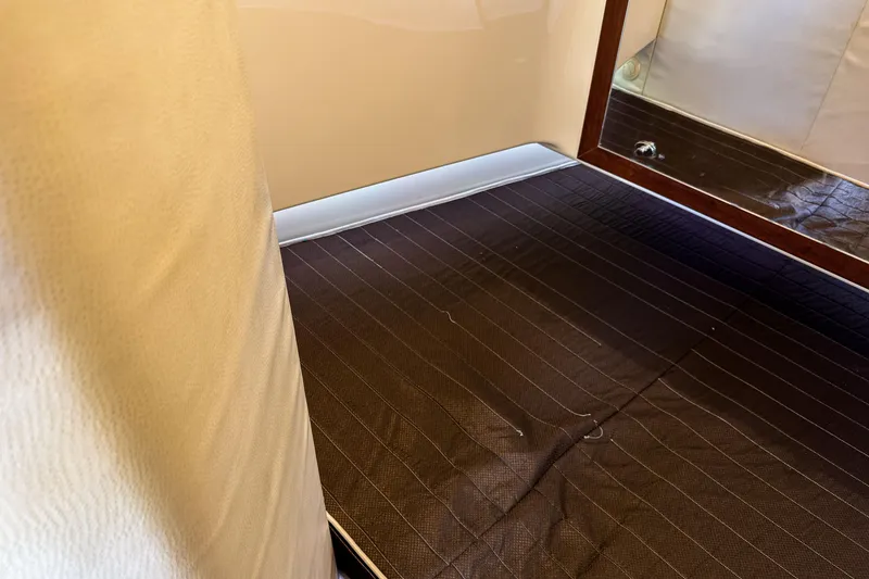 Slide: The Image of Interior view of 2016 SeaVee 430 boat cabin with brown flooring and beige walls. - 42