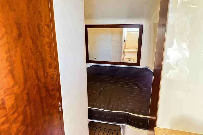 Slide: The Image of 2016 SeaVee 430 cabin interior with bed, wooden accents, and mirror. - 44