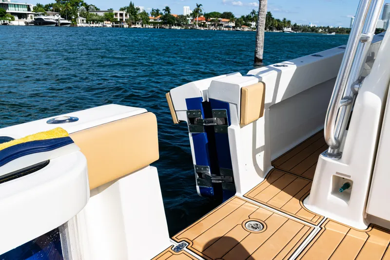 Slide: The Image of 2016 SeaVee 430 boat deck with open transom door, docked by waterfront homes. - 51